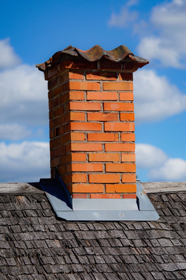 Masonry chimney above a tiled roofline — Chimney Odor Removal in Pinecrest, FL